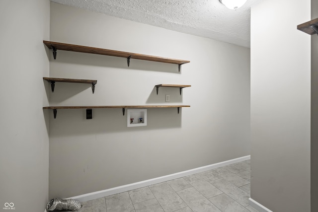 washroom featuring laundry area, a textured ceiling, washer hookup, and baseboards