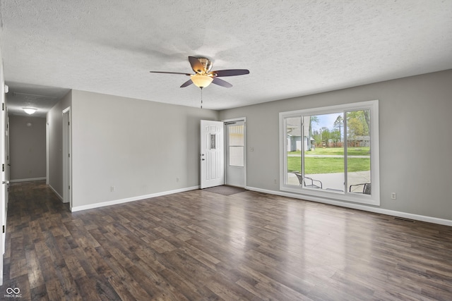 unfurnished living room with a ceiling fan, baseboards, dark wood-style floors, and a textured ceiling