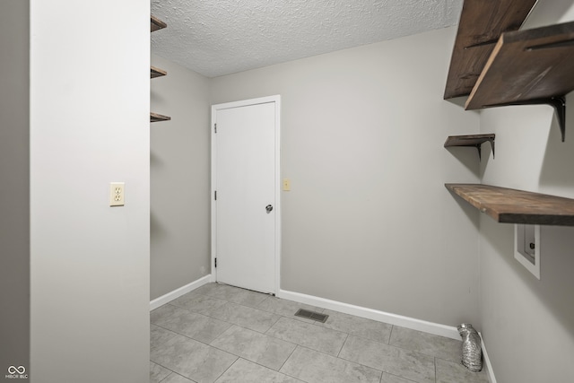 clothes washing area featuring laundry area, visible vents, baseboards, a textured ceiling, and hookup for an electric dryer