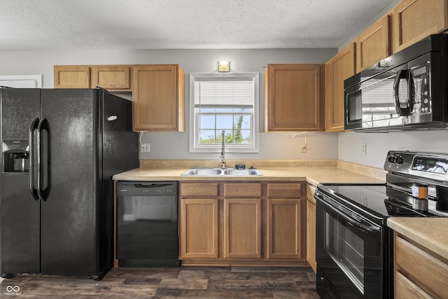 kitchen with light countertops, a textured ceiling, a sink, and black appliances