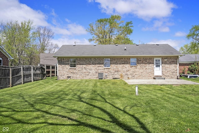 back of property with fence, central air condition unit, brick siding, a lawn, and a patio