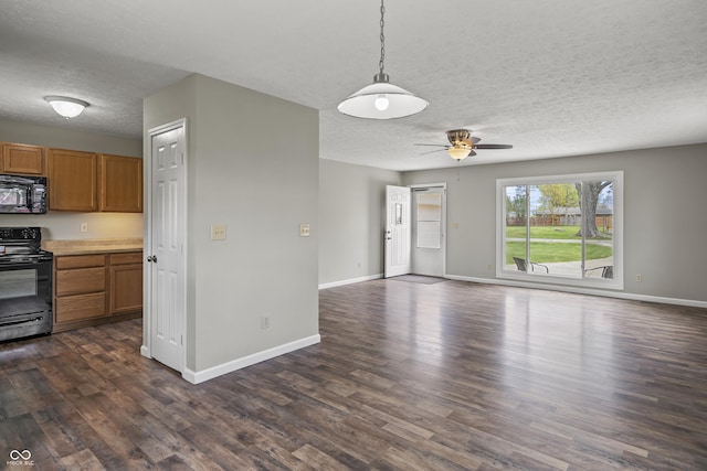 interior space featuring black appliances, brown cabinets, a textured ceiling, and open floor plan