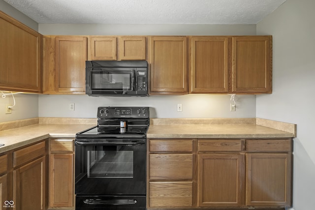 kitchen with light countertops, a textured ceiling, brown cabinets, and black appliances