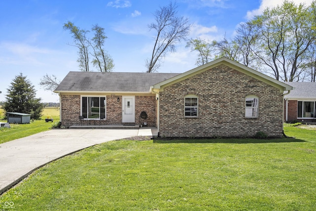 ranch-style home featuring brick siding, driveway, and a front yard