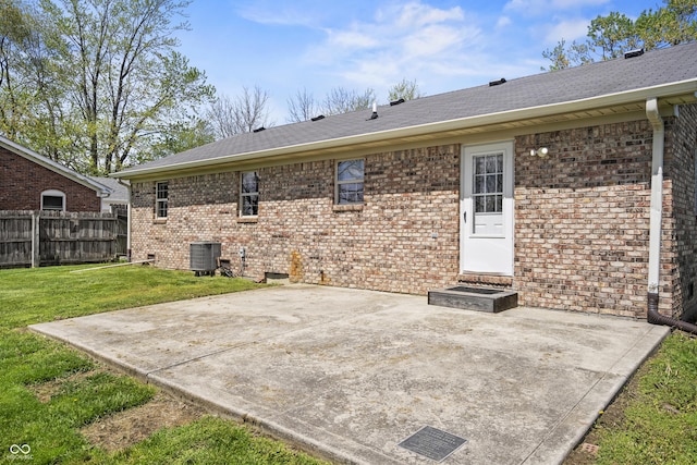 rear view of property with a patio area, brick siding, central AC, fence, and a yard