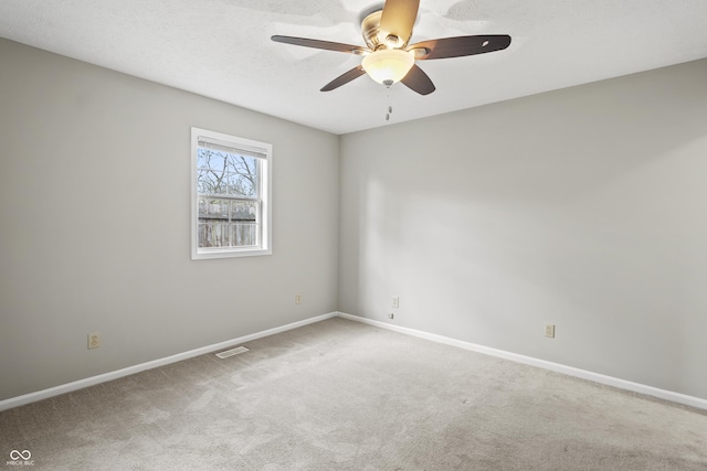unfurnished room featuring ceiling fan, visible vents, baseboards, and carpet