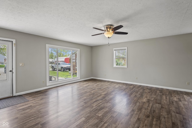 spare room with dark wood-type flooring, a textured ceiling, baseboards, and ceiling fan