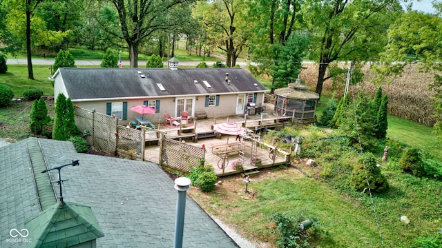back of property with a deck, a gazebo, and fence