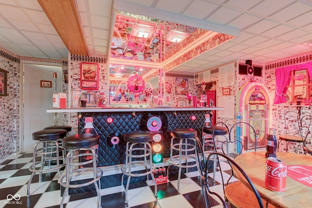 bar featuring a bar, tile patterned floors, and wallpapered walls