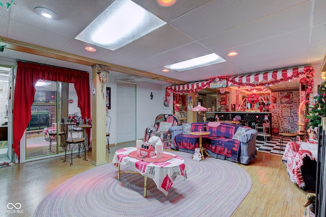 interior space with a drop ceiling and wood finished floors