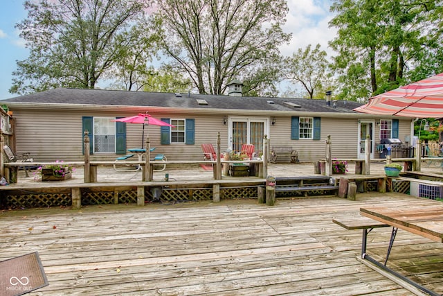 back of house with a wooden deck and a chimney