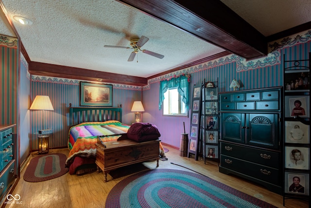 bedroom featuring ornamental molding, wallpapered walls, a textured ceiling, and wood finished floors