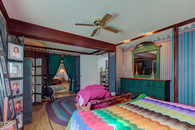bedroom featuring a ceiling fan, a textured ceiling, wood finished floors, and beam ceiling