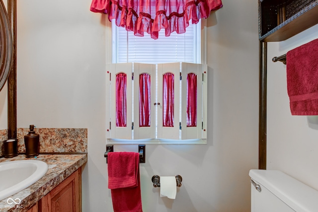 half bathroom with vanity and toilet