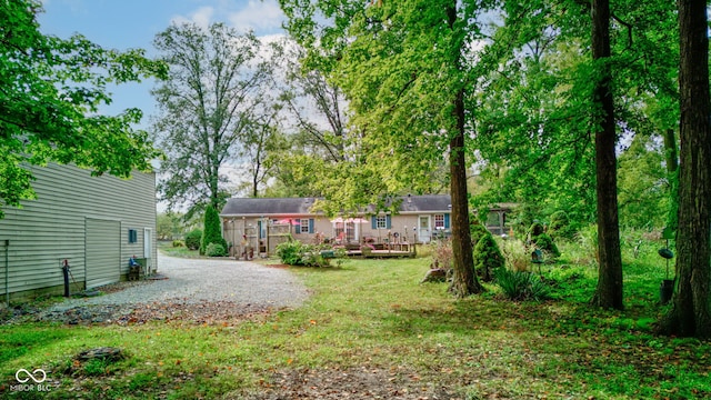view of yard with a wooden deck and driveway