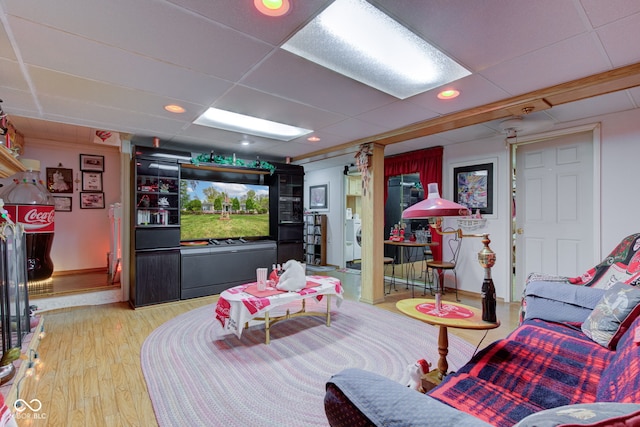 game room with baseboards, light wood-style flooring, and a paneled ceiling