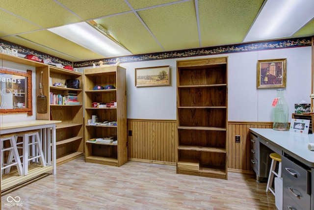home office featuring a paneled ceiling, wood finished floors, and a wainscoted wall