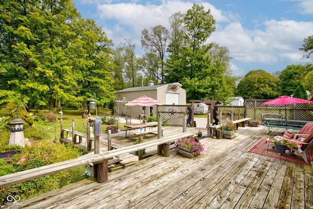 wooden deck featuring an outdoor structure, outdoor dining area, and a storage unit