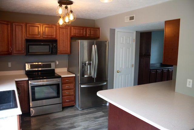 8912 Hosta Way, Indianapolis, IN 46113 - kitchen featuring appliances with stainless steel finishes, brown cabinets, wood finished floors, light countertops, and pendant lighting
