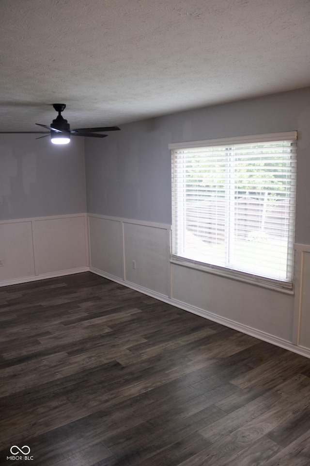 8912 Hosta Way, Indianapolis, IN 46113 - spare room featuring a ceiling fan, a textured ceiling, dark wood finished floors, wainscoting, and plenty of natural light