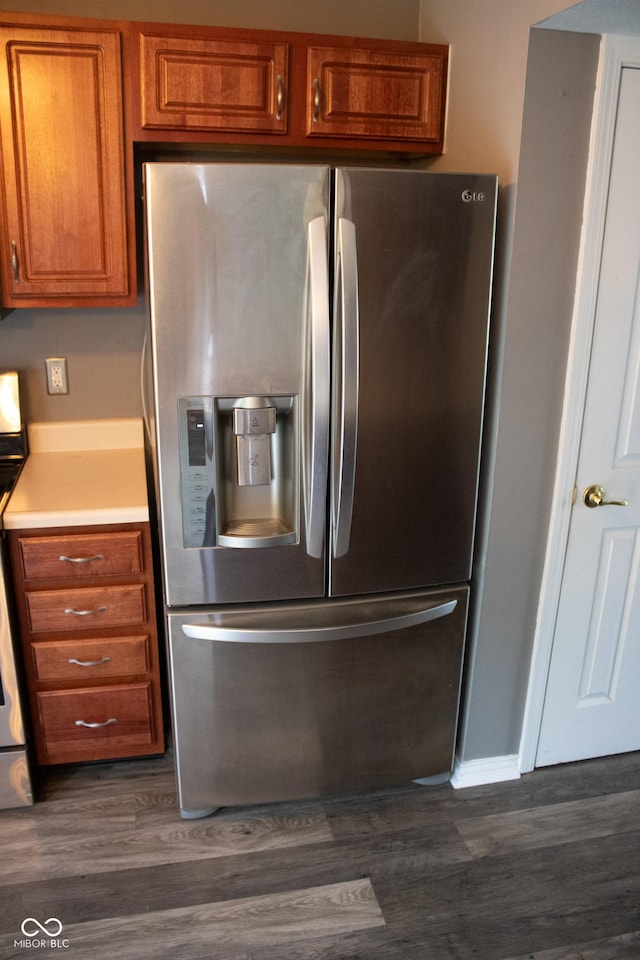 8912 Hosta Way, Indianapolis, IN 46113 - kitchen featuring appliances with stainless steel finishes, brown cabinetry, dark wood-type flooring, and light countertops