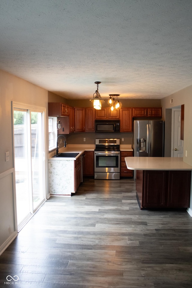 8912 Hosta Way, Indianapolis, IN 46113 - kitchen with stainless steel appliances, a textured ceiling, light countertops, wood finished floors, and brown cabinets
