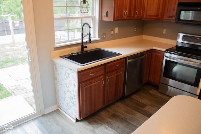 8912 Hosta Way, Indianapolis, IN 46113 - kitchen featuring appliances with stainless steel finishes, dark wood finished floors, light countertops, and brown cabinetry
