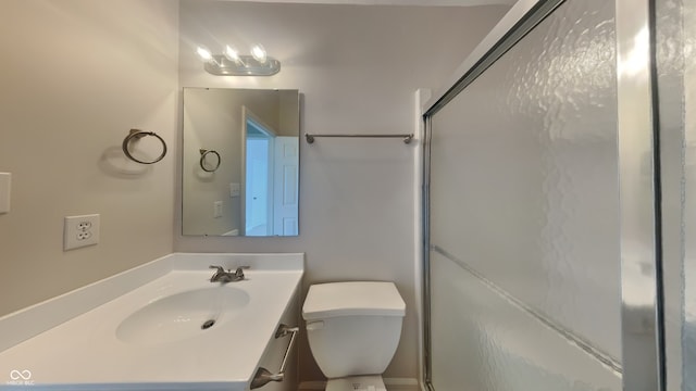 bathroom featuring vanity, toilet, and a stall shower