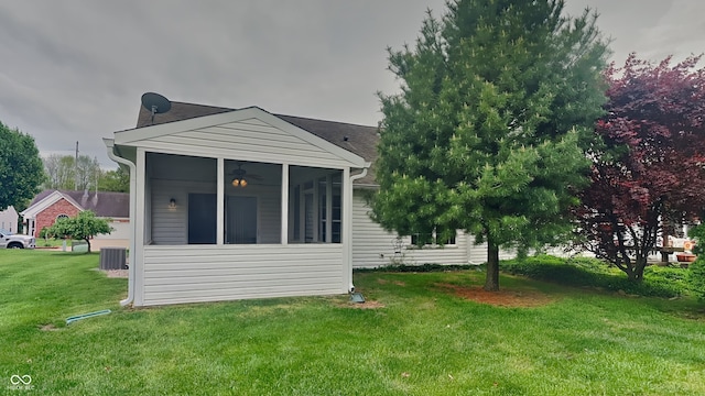 rear view of property with a yard, cooling unit, and a sunroom