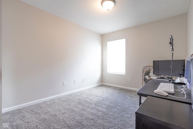 carpeted home office featuring baseboards