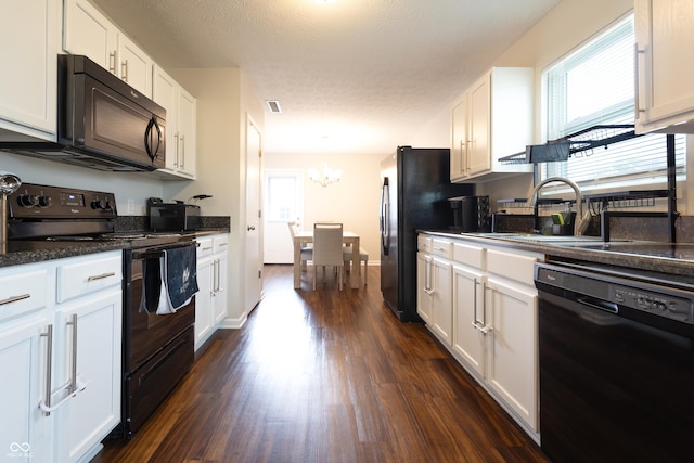 kitchen featuring black appliances, dark wood finished floors, a chandelier, and white cabinets