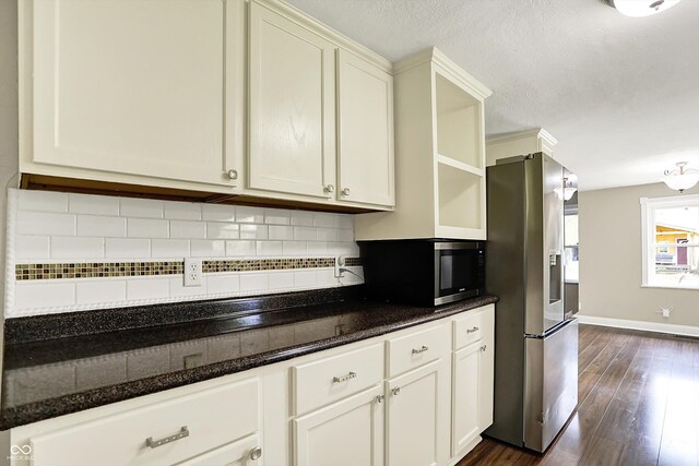 kitchen featuring stainless steel appliances, open shelves, dark wood finished floors, backsplash, and dark stone counters