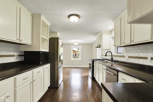 kitchen with stainless steel appliances, a sink, open shelves, dark countertops, and baseboards