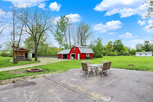 view of patio / terrace with a barn, an outbuilding, and a fire pit