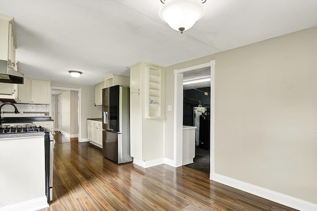 kitchen featuring stainless steel appliances, baseboards, dark wood finished floors, and under cabinet range hood
