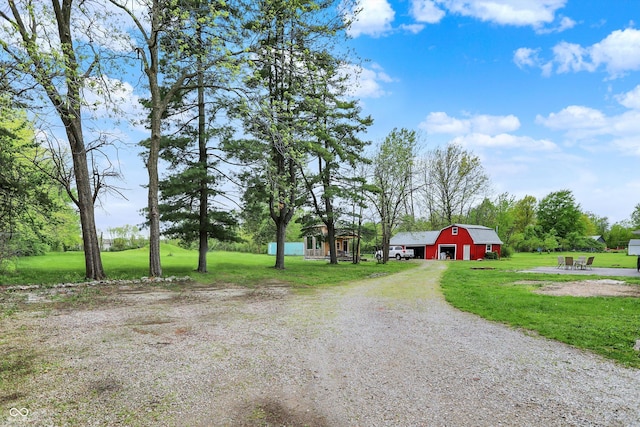 view of dirt / gravel driveway with a barn