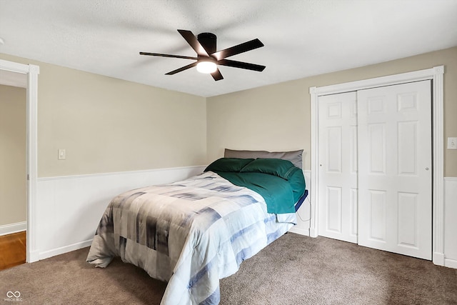 carpeted bedroom featuring ceiling fan, a closet, and baseboards