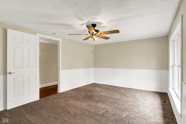 unfurnished bedroom featuring carpet flooring, a textured ceiling, a ceiling fan, and baseboards