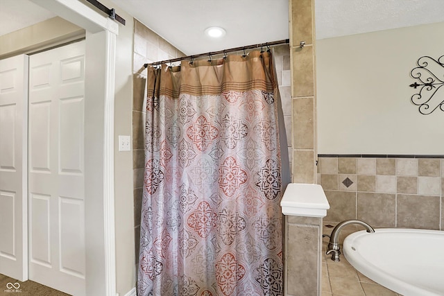 bathroom with tile walls, a bathtub, a shower with curtain, and tile patterned flooring