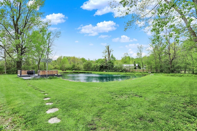 view of green lawn with a water view