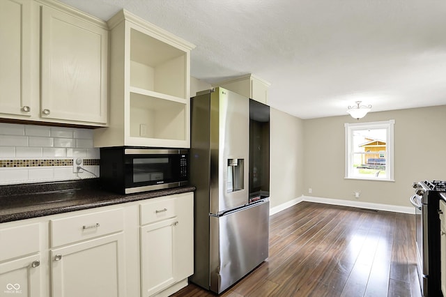 kitchen with stainless steel appliances, open shelves, tasteful backsplash, dark wood finished floors, and dark countertops