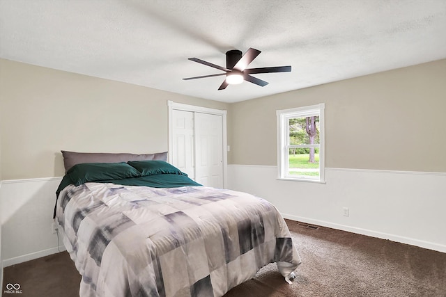 carpeted bedroom featuring baseboards, a closet, ceiling fan, and a textured ceiling