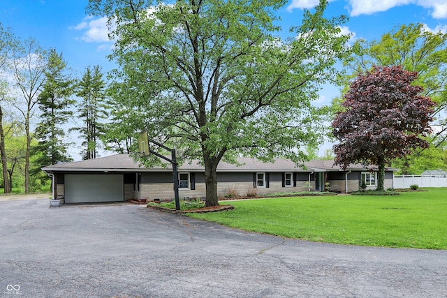 single story home featuring an attached garage and asphalt driveway