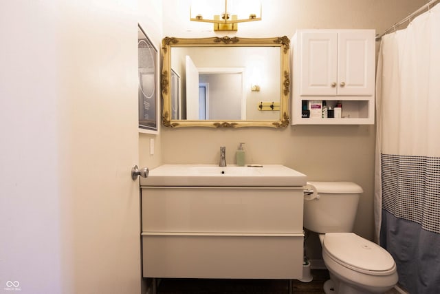 bathroom featuring curtained shower, vanity, and toilet