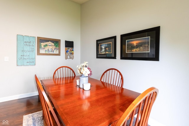 dining space with baseboards and dark wood finished floors