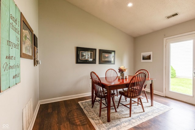 dining room with visible vents, baseboards, lofted ceiling, and dark wood-style floors