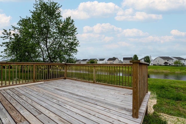 wooden terrace featuring a lawn, a water view, and a residential view