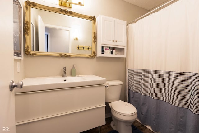 bathroom featuring toilet, curtained shower, and vanity