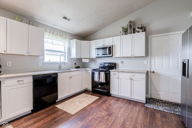 kitchen with a sink, black appliances, visible vents, dark wood finished floors, and vaulted ceiling
