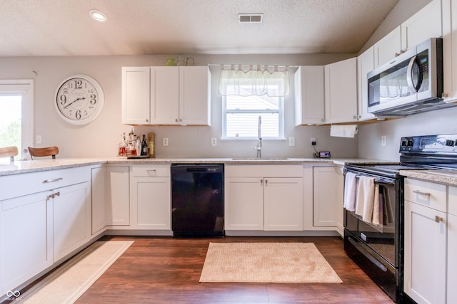 kitchen featuring a sink, a textured ceiling, black appliances, visible vents, and white cabinets